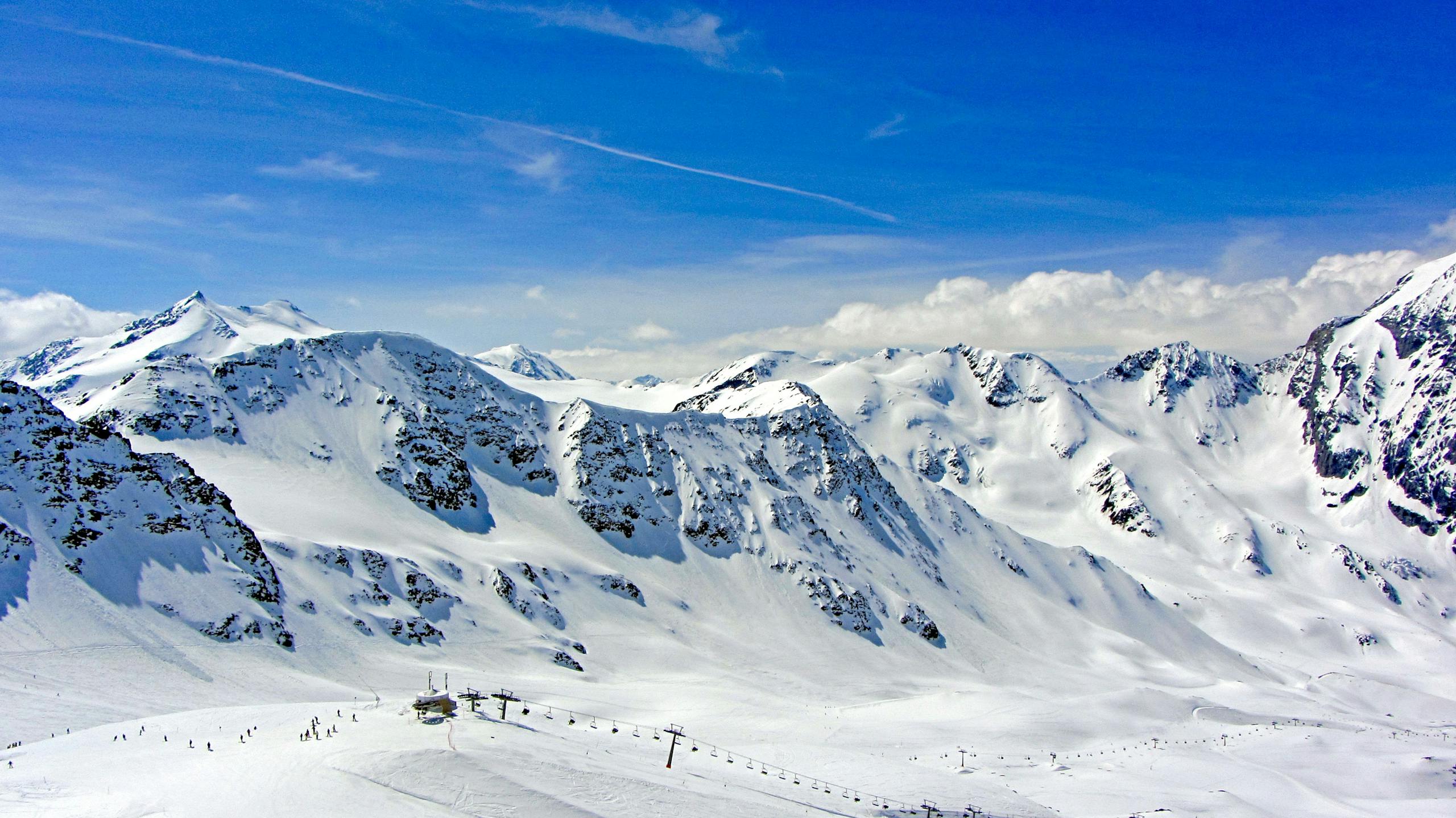 A breathtaking view of snow-covered alpine mountains under a clear blue sky, ideal for winter sports.