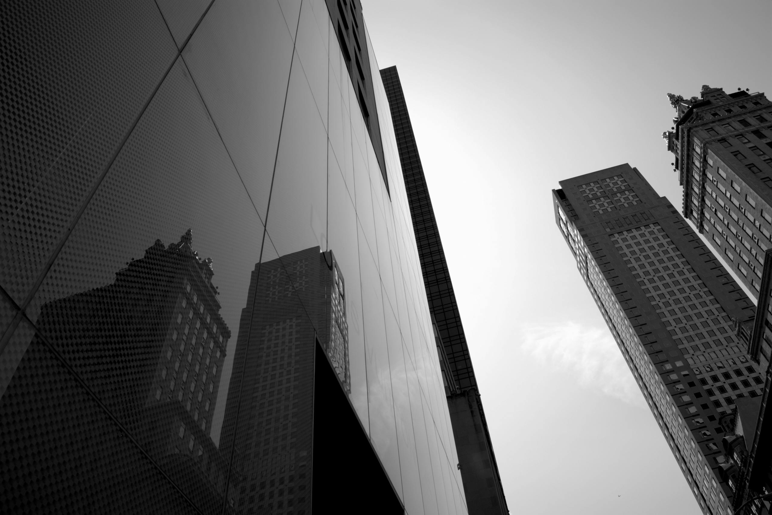 Low angle view of modern skyscrapers in a cityscape with reflections.