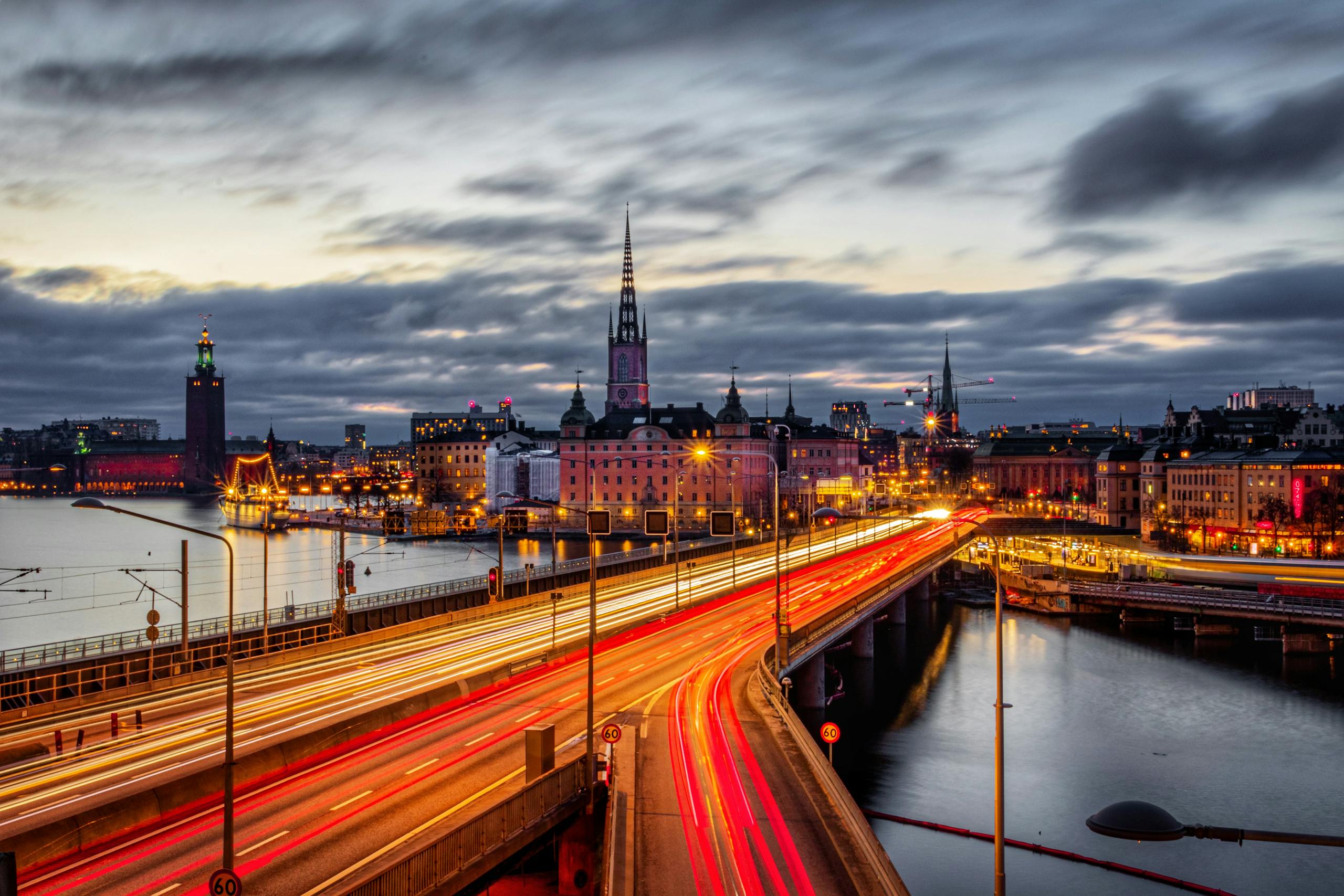 Stunning long exposure shot of Stockholm's illuminated cityscape and Centralbron Bridge at dusk.